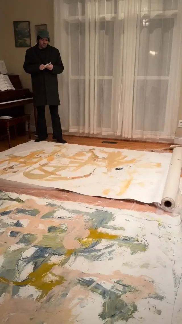 Two large canvases rolled out on the studio floor